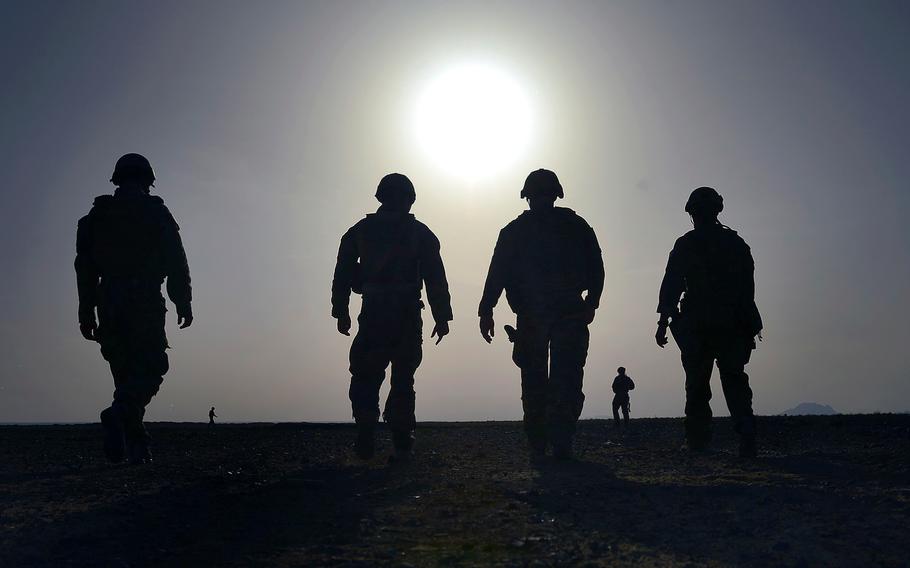 U.S. military Explosive Ordnance Disposal technicians walk toward a blast pit after detonating four 500-pound bombs during a training event at Kandahar Air Field, Afghanistan, on Wednesday, March 16, 2014.