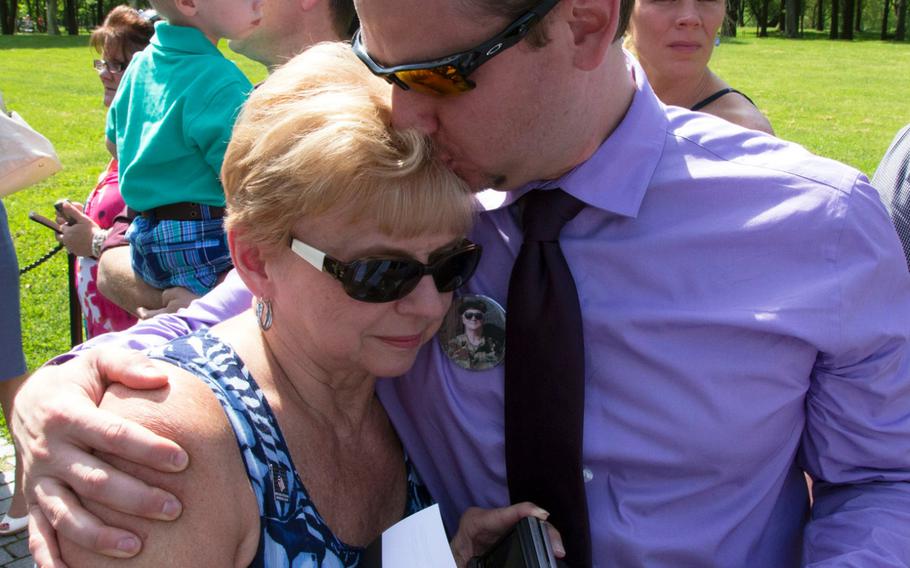 Pfc. Henry J. Drozdowski Jr.'s widow, Sophia, gets a hug from her son Brian after a ceremony at the Vietnam Veterans Memorial in Washington, D.C. on May 11, 2014 marking the addition of 13 names to the Wall and the change of status of eight others.