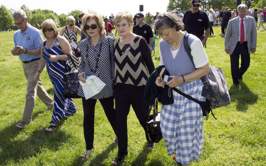 Friends and relatives of fallen servicemembers whose names have been added to the Vietnam Veterans Memorial in Washington, D.C.this year walk to the Wall after a  ceremony on May 11, 2014.