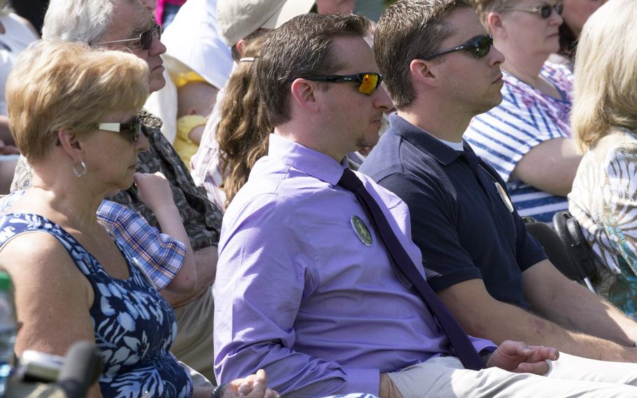 Friends and relatives listen to a speaker during a ceremony at the Vietnam Veterans Memorial in Washington, D.C. on May 11, 2014 marking the addition of 13 names to the Wall and the change of status of eight others.