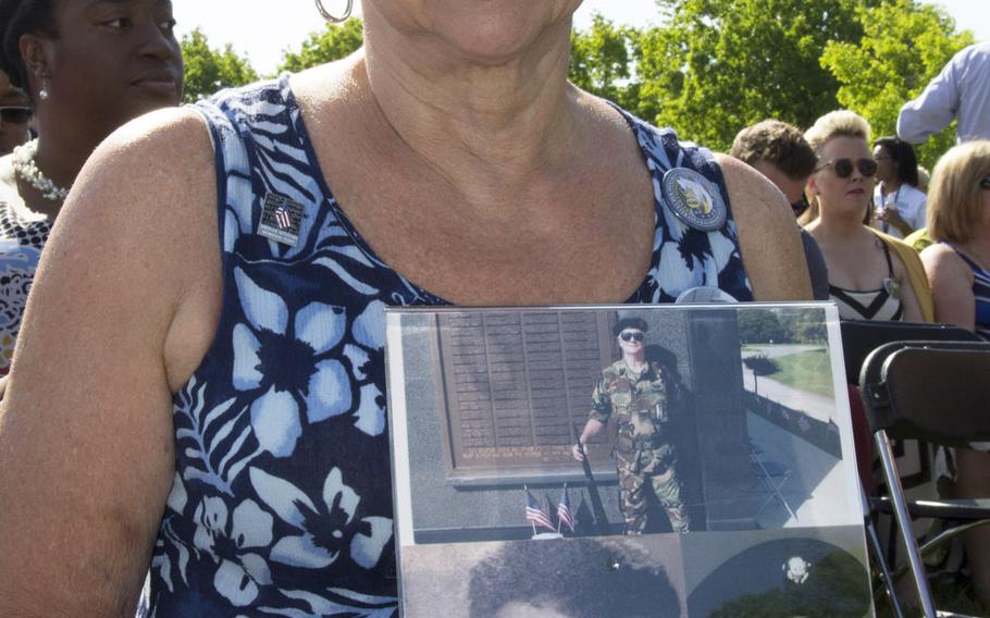 Sophia Drozdowski holds photos of her late husband, Pfc. Henry J. Drozdowski Jr., before a ceremony at the Vietnam Veterans Memorial in Washington, D.C. on May 11, 2014 marking the addition of 13 names to the Wall and the change of status of eight others.