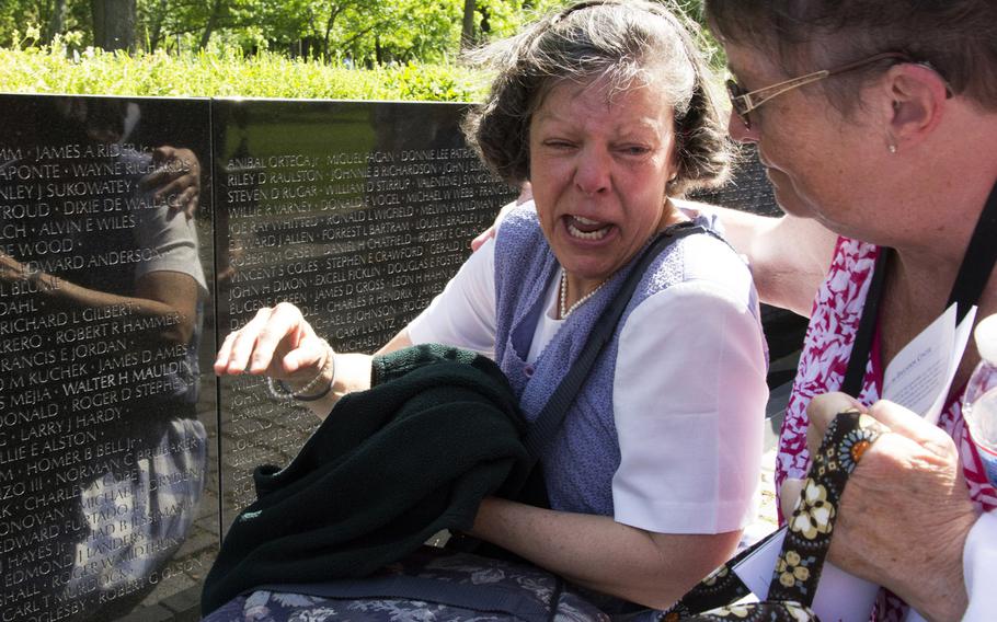 Elizabeth Swiriduk of Tamworth, N.H. is overcome with emotion as she sees the name of her father, Walter H. Mauldin, on the Vietnam Veterans Memorial wall in Washington for the first time on May 11, 2014. Master Sgt. Mauldin, who died in 1968, is one of 13 Vietnam War casualties whose names were added to the wall this year. Eight others had their status changed from missing to deceased, and the addition of a 14th name was delayed until 2015 because of an error.