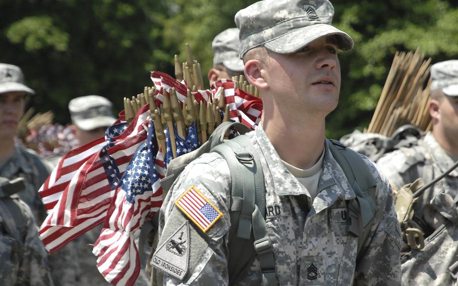 Soldiers head out to plant flags at graves at a "Flags In" ceremony at Arlington National Cemetery on May 22, 2014, to honor fallen troops for Memorial Day. 
