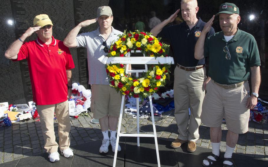 Vietnam veterans Joseph Tomlinson and Tom Cannon, Marine Corps Col. Paul Rock Jr. and veteran Joe Scholle, with a wreath placed on  behalf of the U.S. Marine Corps Helicopter Association ("Pop-A-Smoke") on Memorial Day 2014 at the Vietnam Veterans Memorial in Washington, D.C.