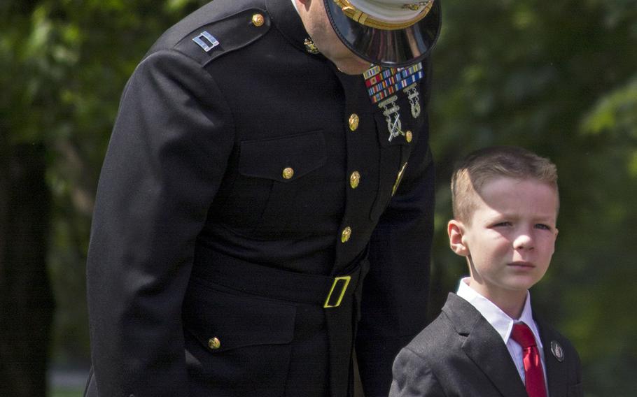 A Marine and his son wait their turn to recite the name of a loved one who was a Vietnam veteran at the In Memory Day observance on Saturday, June 14, 2014. 