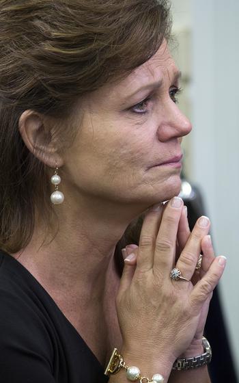 Kyle Carpenter's mother, Robin, listens as her son speaks to reporters in the White House briefing room after his Medal of Honor ceremony, June 19, 2014.