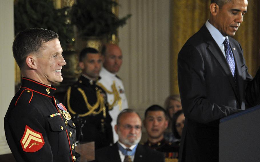 Retired Marine Corps Cpl. Kyle Carpenter laughs as President Barack Obama talks about him at the White House, June 19, 2014.