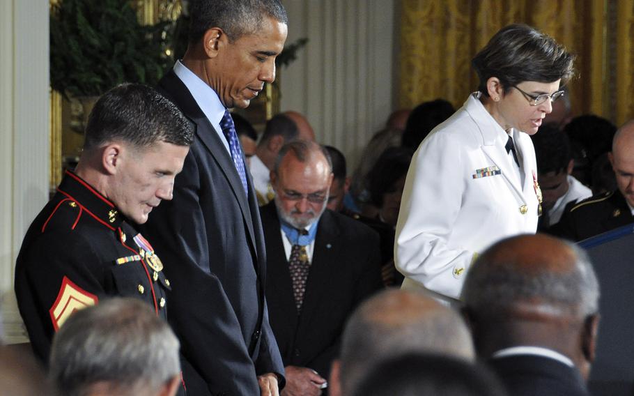 President Barack Obama and soon-to-be Medal of Honor recipient Cpl. Kyle Carpenter bowthteir heads as Chaplain (Rear Admiral) Margaret Kibben gives the invocation at the White House, June 19, 2014.