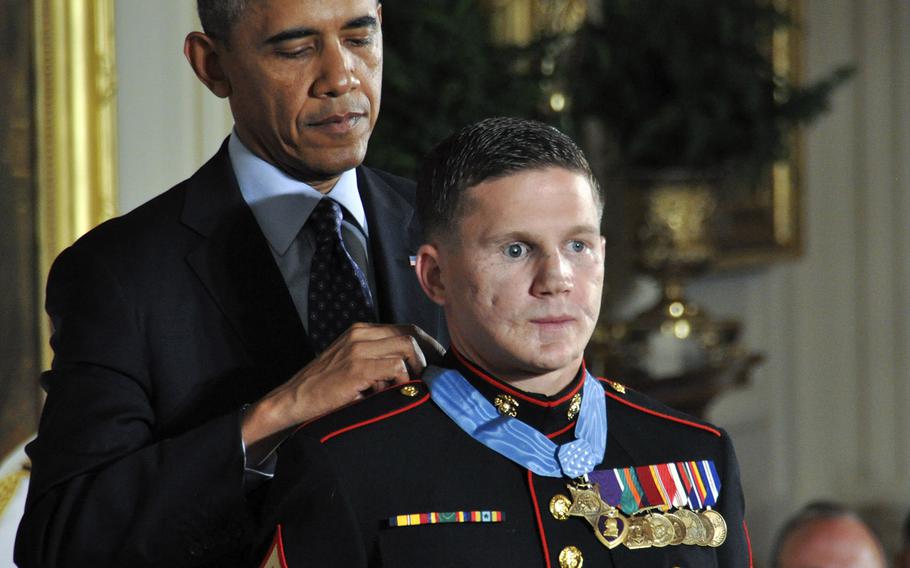 President Barack Obama awards the Medal of Honor to retired Marine Corps Cpl. Kyle Carpenter at the White House, June 19, 2014. In the background is Vietnam War MOH recipient Brian Thacker.