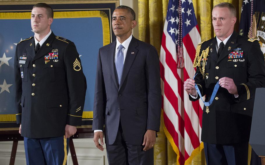 Former Army Staff Sgt. Ryan Pitts, Pesident Barack Obama and a military aide listen as Pitt's Medal of Honor citation is read during the ceremony for  at the White House, July 21, 2014.