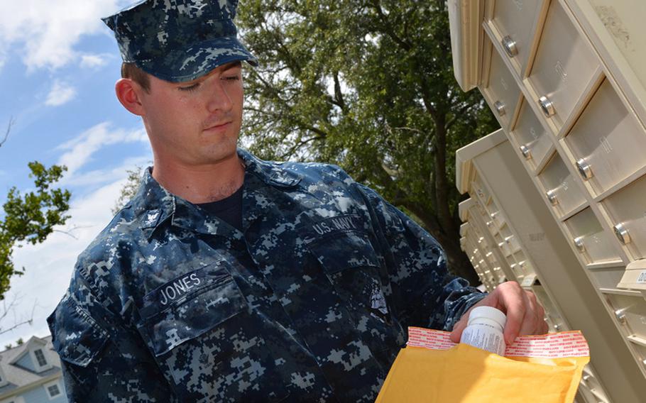 A sailor receives prescription medications directly to his home via TRICARE Pharmacy Home Delivery. Prescriptions filled by base pharmacies would remain free, but the current $17 co-pay at retail outlets for a 30-day supply of a brand name drug on the military formulary would jump to $26 in January.