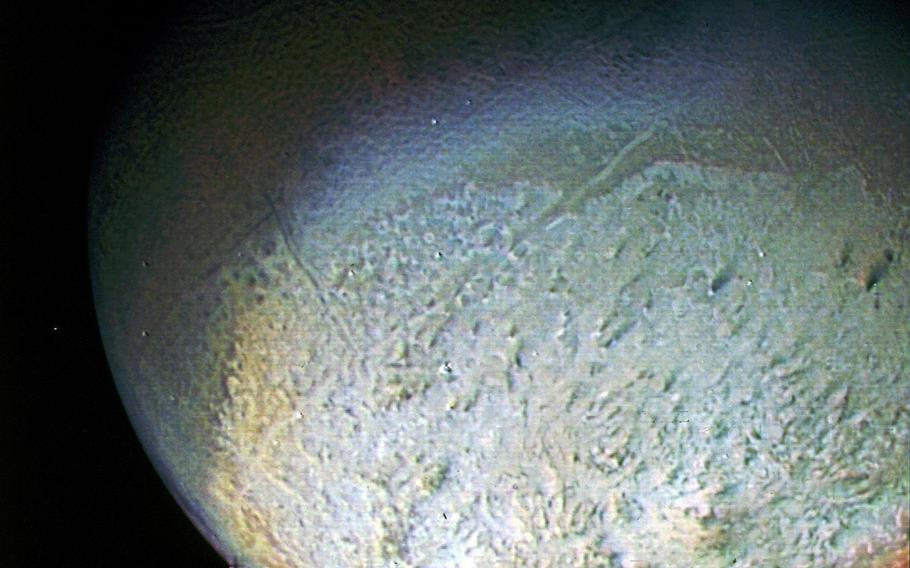 A color photo of Neptune's largest moon Triton, taken on Aug. 24, 1989. Voyager 2 was 333,000 miles away from Earth at this point. The image was made from pictures taken through the green, violet and ultraviolet filters. In this technique, regions that are highly reflective in the ultraviolet appear blue in color. In reality, there is no part of Triton that would appear blue to the eye.