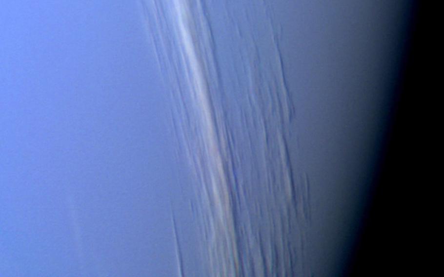 Voyager 2 snapped this close-up shot of Neptune in Aug. 1989. The shadow of the white clouds indicates a great distance between the top cloud layer and the underlying clouds. NASA says the white clouds appear to reach about 31 miles up. 