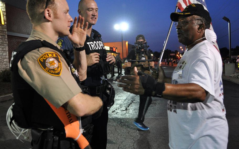 A protester pleads with police Tuesday in Ferguson, Mo. Protests over the shooting of a black teen by a white police officer have escalated into riots in the St. Louis suburb, and the Missouri governor recently made the controversial decision to call up National Guard troops to assist law enforcement. 