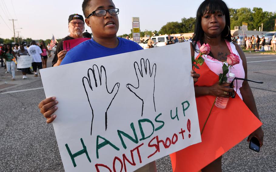 Protesters in Ferguson, Mo., on Tuesday. Protests over the shooting of a black teen by a white police officer have escalated into riots, and the Missouri governor recently made the controversial decision to call up National Guard troops to assist law enforcement.