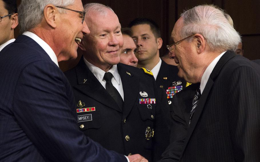 Secretary of Defense Chuck Hagel and Joint Chiefs of Staff Chairman Gen. Martin Dempsey talk with Armed Forces Committee Chairman Sen. Carl Levin, D-Mich., before a hearing on Sept. 16, 2014.