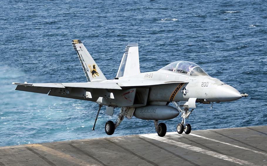 An F/A-18F Super Hornet lands aboard the aircraft carrier USS George H.W. Bush in the Persian Gulf on Tuesday, Sept. 23, 2014, after conducting strike missions against Islamic State group targets in Syria.
