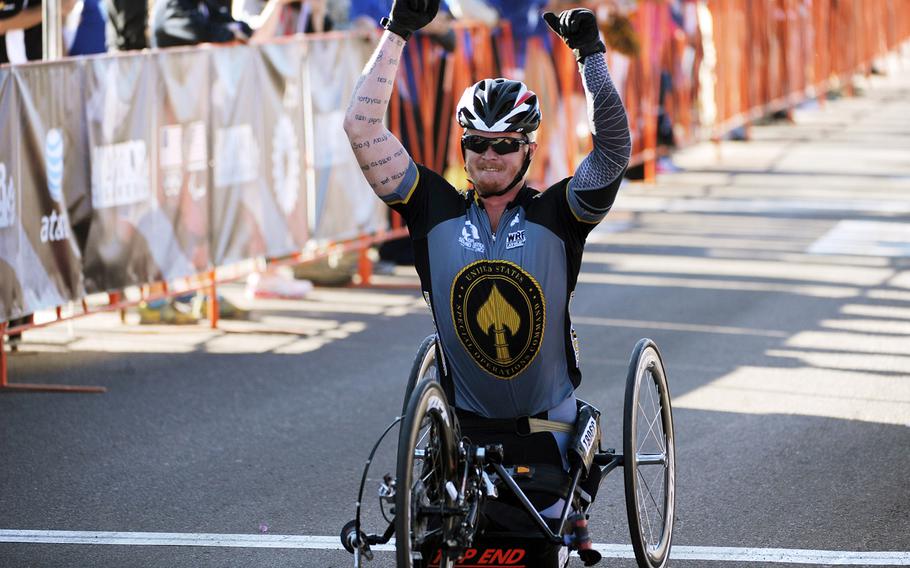 Cpl. Justin Gaertner of the Special Operations Command team celebrates his first place finish in a hand cycling event at the 2014 Warrior Games at Fort Carson, Colo., on Sept. 29, 2014. 