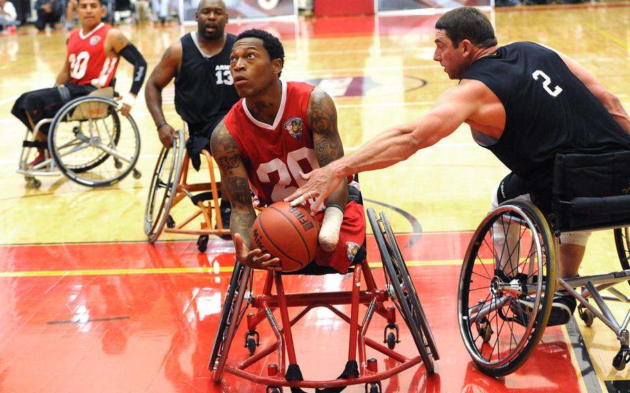 Marine Corps team Sgt. Anthony McDaniel Jr. evades Army as he drives to the Army net during the gold medal basketball round of the 2014 Warrior Games at the Olympic Training Center in Colorado Springs, Colo. Oct. 3, 2014. Marine Corps beat Army 42-21.