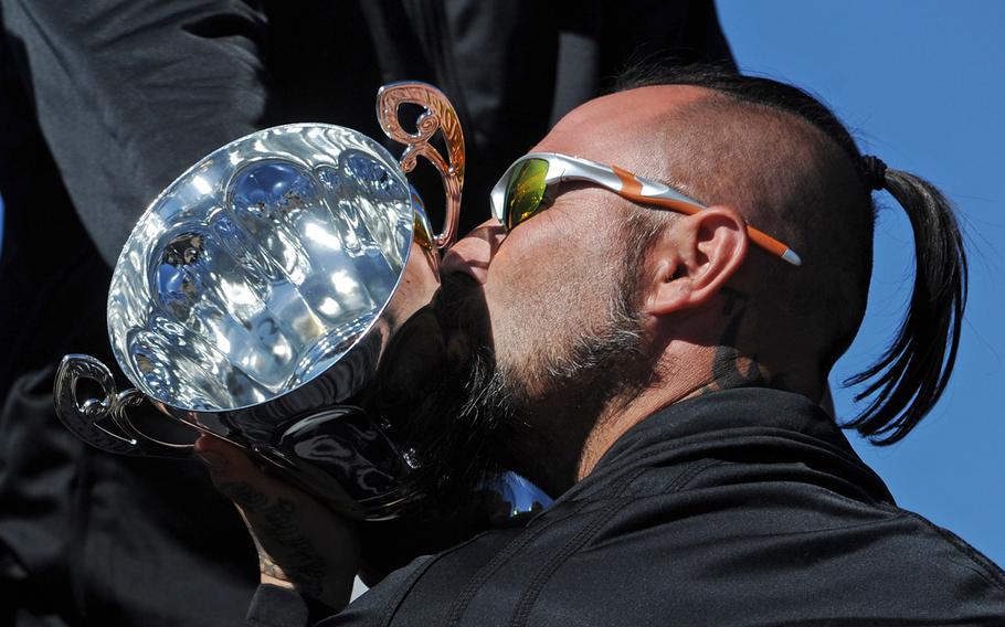Army team's Andrew McCaffrey kisses the 2014 Warrior Games Chairman's Cup at a tailgate party for wounded warrior athletes outside the Navy versus Air Force football game at the Air Force Academy in Colorado Springs, Colo., on Oct. 4, 2014.