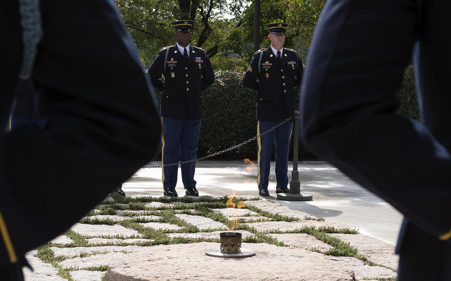 Servicemembers encircle JFK's grave and the eternal flame during the Wreath Laying Ceremony in Arlington National Cemetery on Oct. 21, 2014.