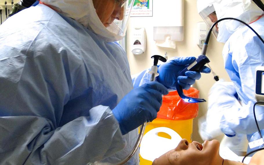 A member of a Defense Department medical team training to assist civilian health care workers with Ebola patients in the U.S., if necessary, practices inserting a breathing tube into a dummy patient Friday, Oct. 24, 2014, at San Antonio Military Medical Center in Texas.