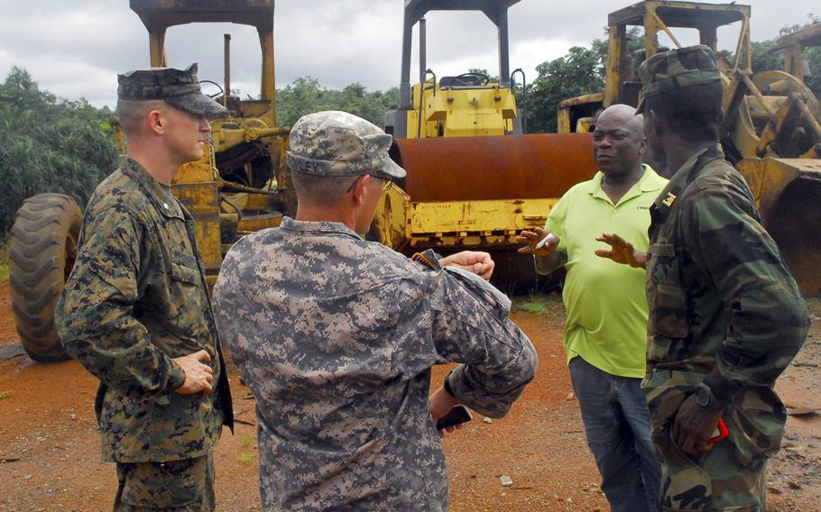 Marine Lt. Col. Doug Woodhams, U.S. Army Africa Sgt. Bromley and Liberian armed forces Capt. Abraham Karmara discuss construction details with a Liberian contractor at the future location of an Ebola treatment unit near Barclayville, Liberia, on Oct. 11, 2014.