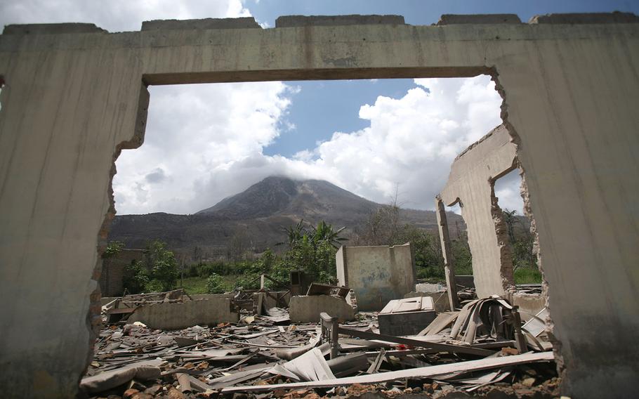 Mount Sinabung is framed by a crumbling building in the abandoned village of Simacem village, North Sumatra, Indonesia, on Oct. 17, 2014. The village was abandoned after its people were evacuated following the eruption of the volcano. Sinabung, among about 130 active volcanoes in Indonesia, has sporadically erupted since 2010 after being dormant for 400 years. More than 22,000 people were evacuated from the area around the 8,530-foot volcano after the eruptions earlier this year that killed at least 16 people. Most have returned home, but about 4,700 remain in evacuation centers. 