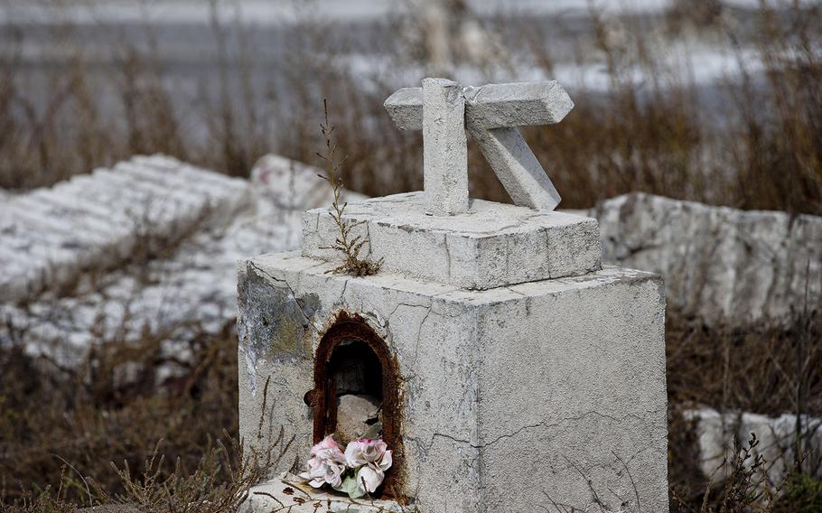 In this May 7, 2013 photo, a cross lies broken on a tomb in the abandoned town of Epecuen, Argentina. This town was once home to 1,500 residents, but they were forced to leave in 1985 when heavy rains made the nearby lake overrun its banks and submerged the town beneath almost 30 feet of water. The town was never rebuilt as the water started to recede.