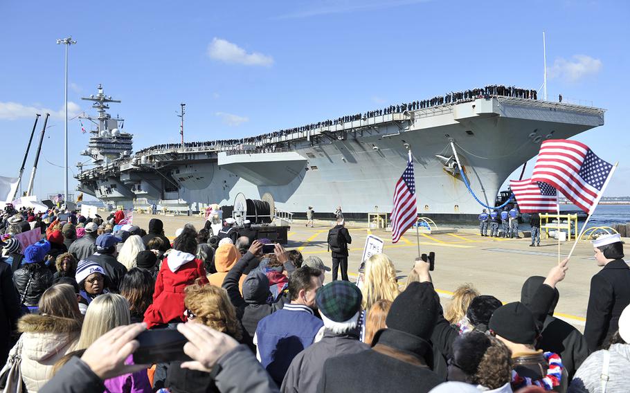 Family and friends wait for Sailors to disembark the aircraft carrier USS George H.W. Bush as the ship returns to Naval Station Norfolk Nov. 15, 2014, after a nine-month deployment in support of maritime security operations and theater security cooperation efforts in the U.S. 5th and 6th Fleet areas of responsibility. 