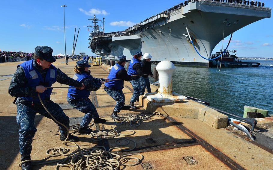 Sailors haul mooring lines for the aircraft carrier USS George H.W. Bush as the ship returns to homeport at Naval Station Norfolk Nov. 15, 2014, after a nine-month deployment supporting Operations Active Endeavor, Inherent Resolve, and Enduring Freedom. 