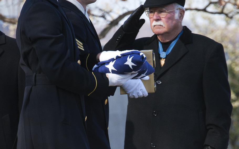 Medal of Honor recipient Harvey Barnum, Jr. salutes as an honor guard passes by carrying the ashes of Army Pvt. Miguel A. Vera, at Arlington National Cemetery on Nov. 20, 2014. Vera, who was killed during the Korean War, was one of 24 soldiers to be presented the Medal of Honor in March after being previously overlooked because of their racial and ethnic backgrounds. Vera was originally buried in Puerto Rico.