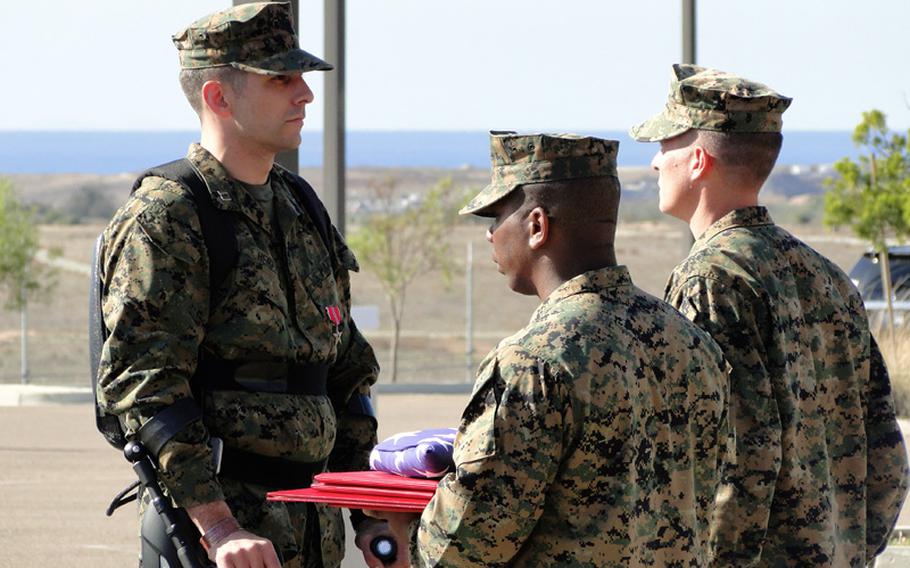 Capt. Derek Herrera, left, received a Bronze Star with V for combat valor and a Navy and Marine Corps Commendation Medal on Friday at Camp Pendleton. Herrera was shot in the spine in Afghanistan in 2012, paralyzing him from the chest down, but he stood and walked during his retirement ceremony with the help of an exoskeleton. 