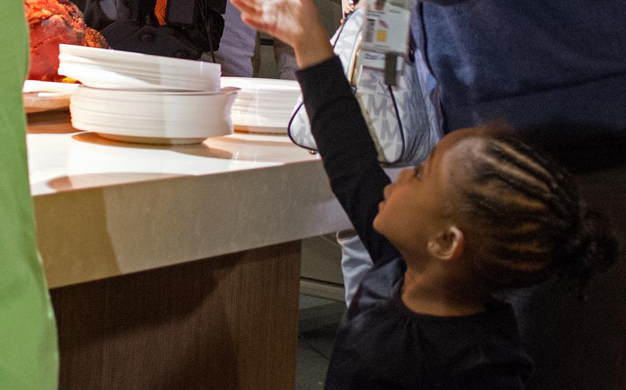 A little girl eagerly offers to help her mother get dinner at the USO in Bethesda, Md., during the Make a Moment Campaign on Nov. 20, 2014.