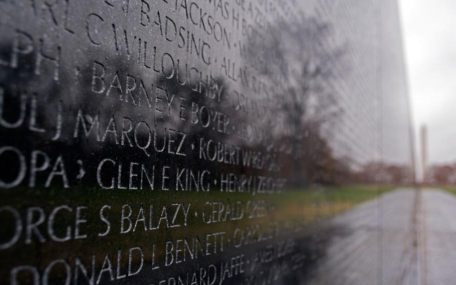 The National Monument and the remaining fall colors are reflected in the Vietnam Veterans Memorial Wall on a dreary Wednesday in Washington, D.C., on Nov. 26, 2014.