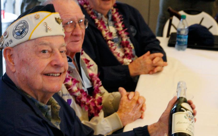 Louis Conter holds the bottle of sparkling wine that he and three other survivors of the 1941 attack on USS Arizona will use for a toast to their fallen shipmates on Sunday, the 73rd anniversary of the Japanese attack on Pearl Harbor. Sitting beside him are fellow survivors Donald Stratton and Lauren Bruner.