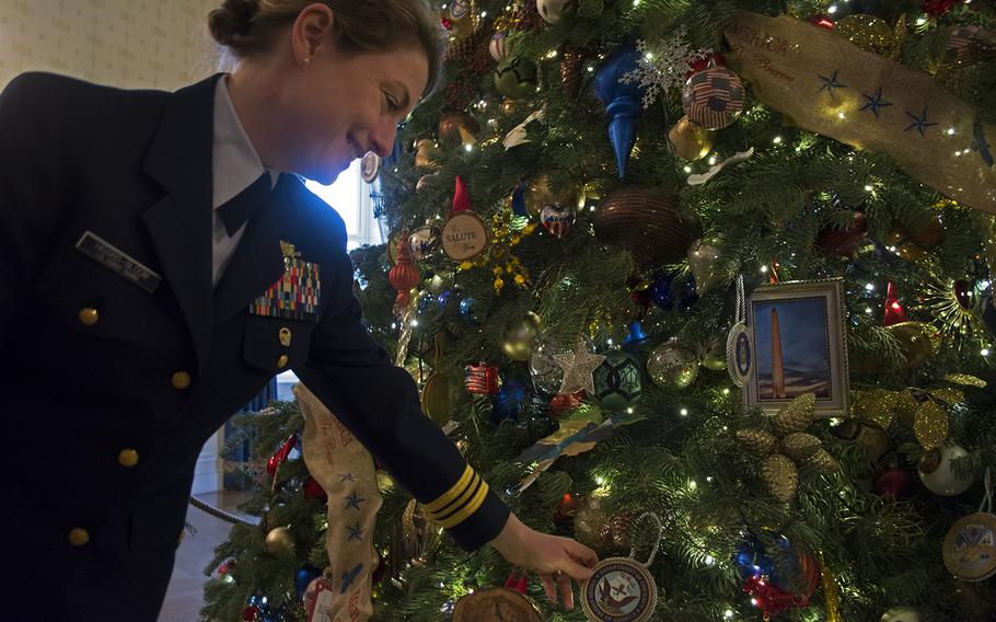 Lt. Commander Kate Higgins-Bloom with the Coast Guard shows off a Navy ornament hanging on the official White House Christmas Tree on Dec. 3, 2014. Her husband, Lt. Commander Zach Bloom, is in the Navy. 