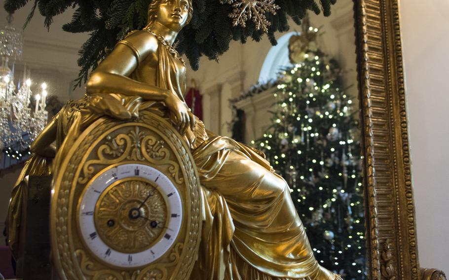 A clock mantel is seen in detail as a Christmas tree is reflected in the mirror at the White House on Dec. 3, 2014.