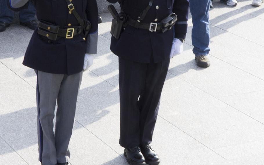 Maine police officers Steven Thibodeau and Kevin Haley salute after placing a wreathe at the grave of Sen. Edward M. Kennedy during Wreaths Across America at Arlington National Cemetery, Dec. 13, 2014.
