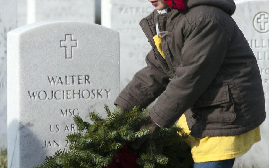 Nathan Anderson places a wreath during Wreaths Across America at Arlington National Cemetery, Dec. 13, 2014. Nathan was with Arlington with his Dad, Navy Lt. Cmdr. Ryan Anderson, along with his Mom, Amy, and brother, Connor.
