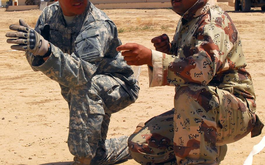A U.S. soldier, left, shows a Peshmerga fighter which way to face his "weapon," during training near Kirkuk, Iraq, on June 14, 2010. Pentagon officials announced Friday, Jan. 16, 2015, that some 400 U.S. military trainers and an unspecified amount of support personnel will be heading to the Middle East to give basic infantry training to moderate Syrian rebels.