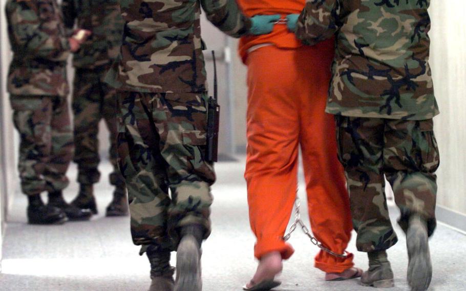 In a 2004 photo, a detainee is escorted to an interrogation room at the Camp Delta detention facility at the U.S. Marine Base in Guantanamo Bay, Cuba.