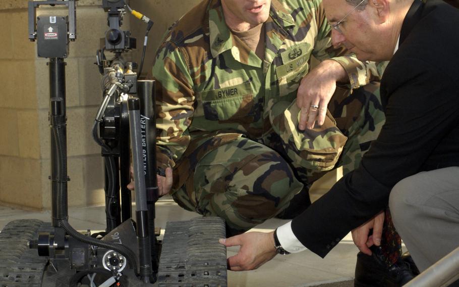 In this file photo from May 2006, Navy Aviation Ordnanceman 1st Class Bryan Bymer explains to then-Navy Secretary Dr. Donald C. Winter some capabilities of the different robots used for Improvised Explosive Device (IED) disposal in Iraq.
