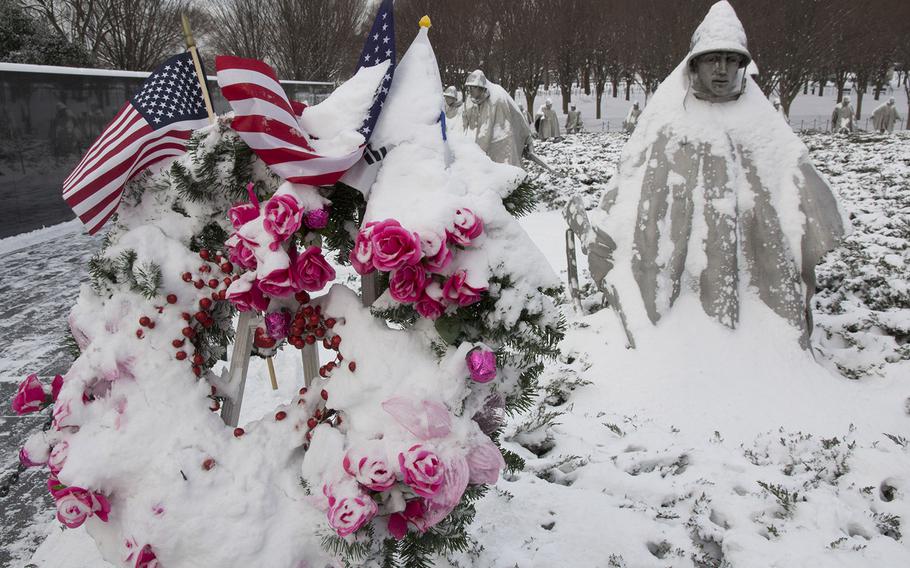 A wreath placed by the Seoul National University College of Commerce's Class of 1963 and one of the statues at the Korean War Veterans Memorial in Washington, D.C., are covered with snow on Feb. 17, 2015.