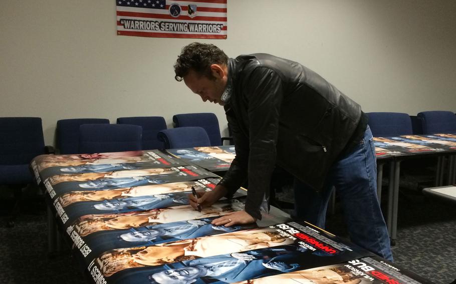 Actor Vince Vaughn signs posters from his new movie, "Unfinished Business," for airmen and their families at Edwards Air Force Base, Calif., on Saturday. Vaughn visited the base to screen the movie for troops.