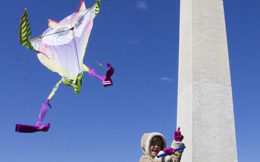 Six-year-old Elee Cie of Silver Spring, Md. guides her kite aloft during the fifth annual Blossom Kite Festival in Washington, D.C., March 28, 2015.