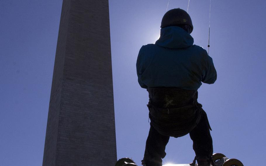 Landboarder Lon Phan of Silver Spring, Md., is silhouetted against the sun as takes to the air in front of the Washington Monument in the early minutes of the fifth annual Blossom Kite Festival in Washington, D.C., March 28, 2015.