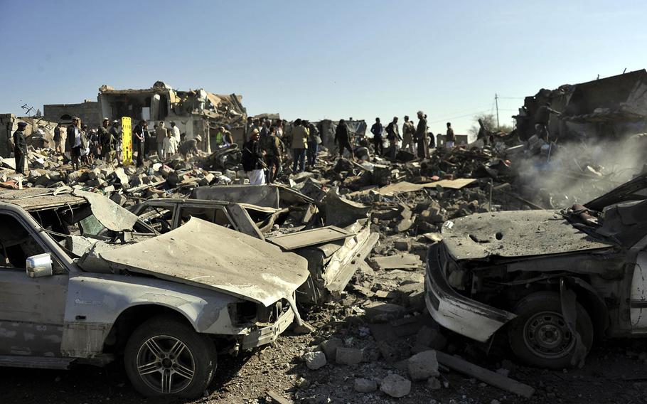 People gather at the bombed site near an air force base to search for casualties in Sanaa, Yemen, on March 26, 2015. 