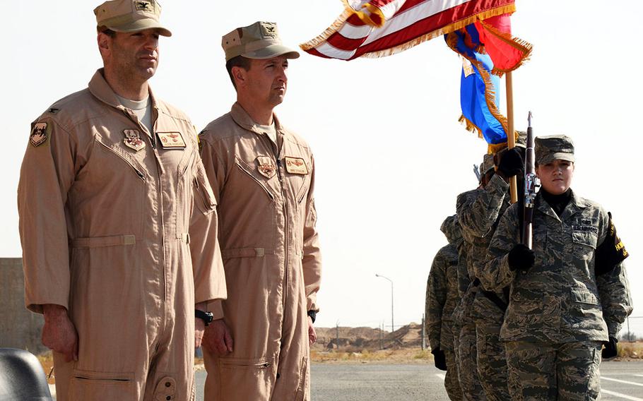 Col. Jason Hanover, left, 386th Air Expeditionary Wing commander, and Col. Michael Stohler, 332nd Air Expeditionary Group commander, stand as the colors are posted during the 332nd AEG reactivation and assumption of command ceremony Nov. 16, 2014.