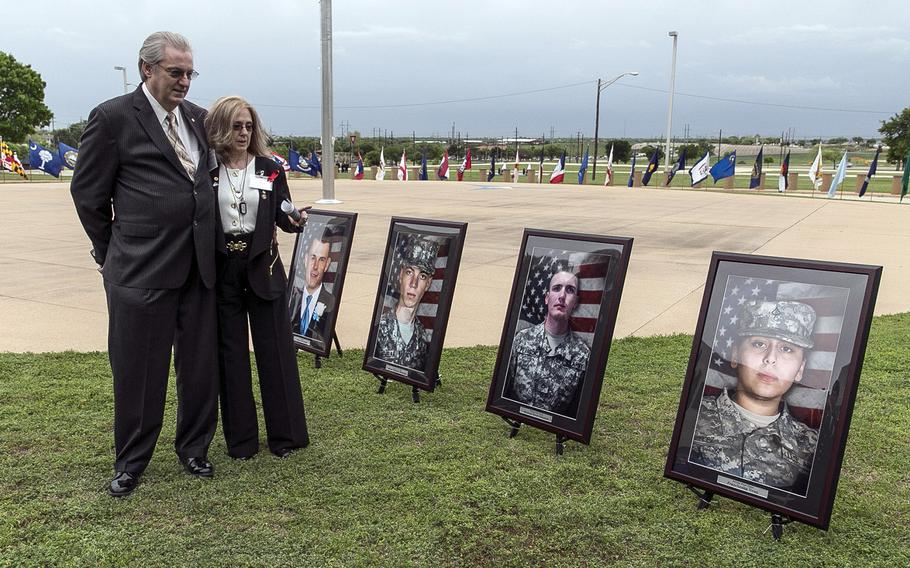 Jeffrey and Sheryll Pearson, parents of Pfc. Michael Pearson, second picture from right, visit in front of his picture prior to a Purple Heart ceremony held at Fort Hood, Texas, on April 10, 2015.